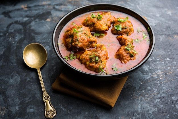 Low carb lauki kofta curry in white bowl with soft golden koftas in thick orange gravy, fresh coriander garnish, side cucumber salad Low carb lauki kofta curry in white bowl with soft golden koftas in thick orange gravy, fresh coriander garnish, side cucumber salad