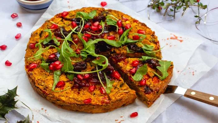 Vegetarian roasted butternut squash with nuts, beans, and tomato chilli sauce in a ceramic dish. Vegetarian roasted butternut squash with nuts, beans, and tomato chilli sauce in a ceramic dish.